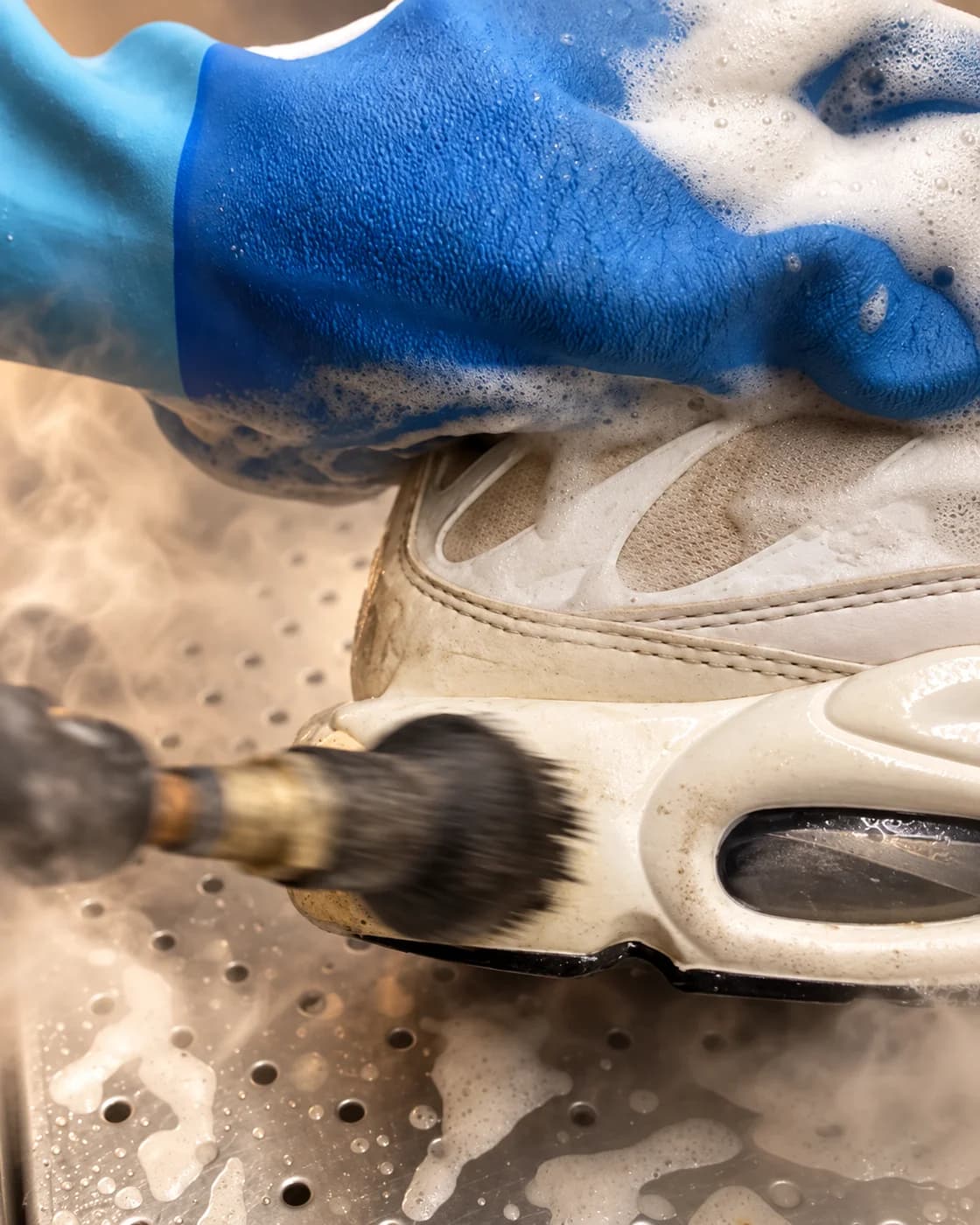 Geste de nettoyage d’une sneaker, avec une légère ambiance vapeur ajoutée